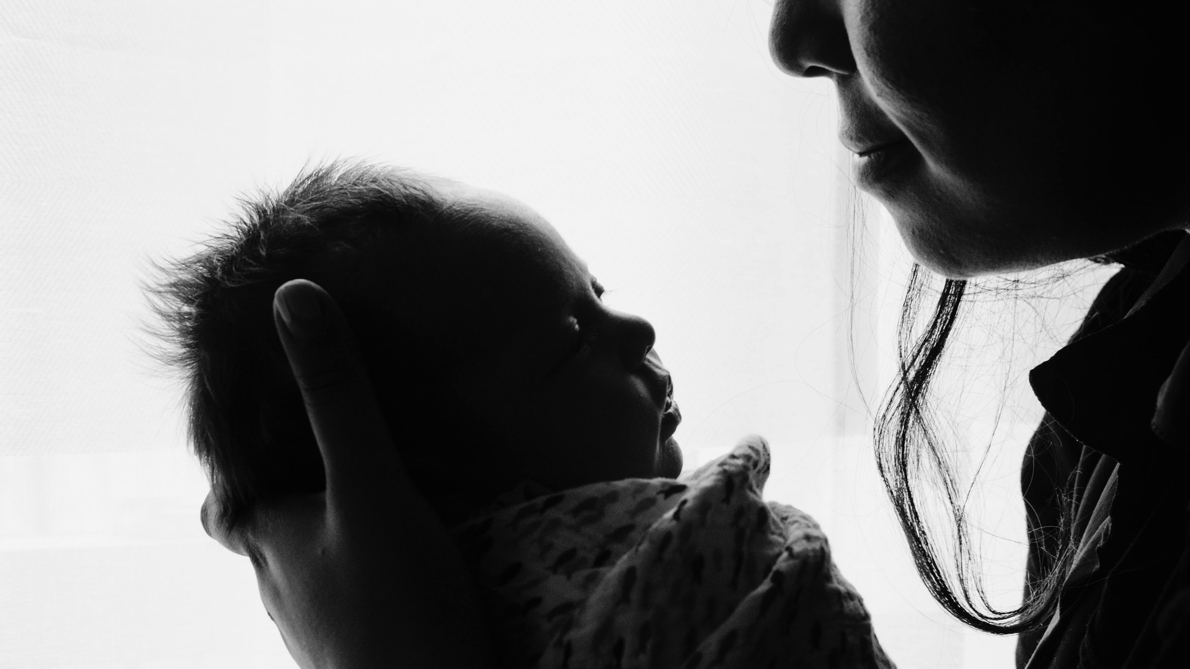 Cover Photo: An image of mother and  child;  the mother is cradling the baby in her hands