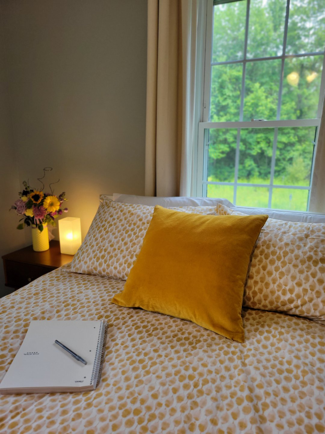 This photo is a close-up of the author's neatly-made bed, on which sits a notebook.